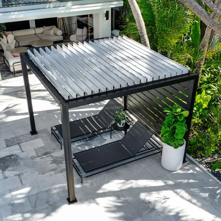 Black K-BANA manual louvered pergola with white louvers and privacy wall, poolside