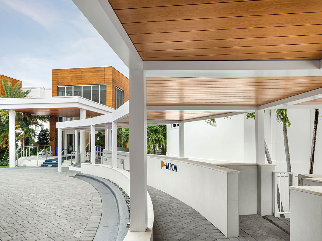 Suite de pergolas en aluminium blanc avec toiture bois à l’entrée d'un club privé