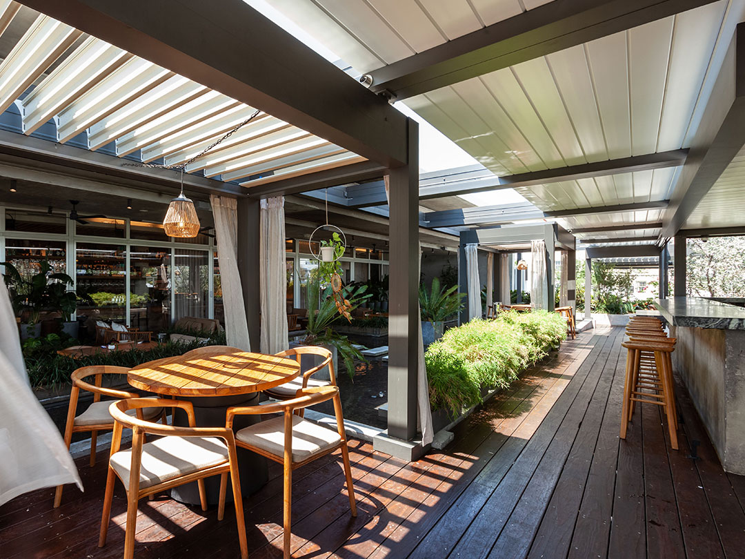 Aménagement de terrasse design sous pergola bioclimatique dans un restaurant