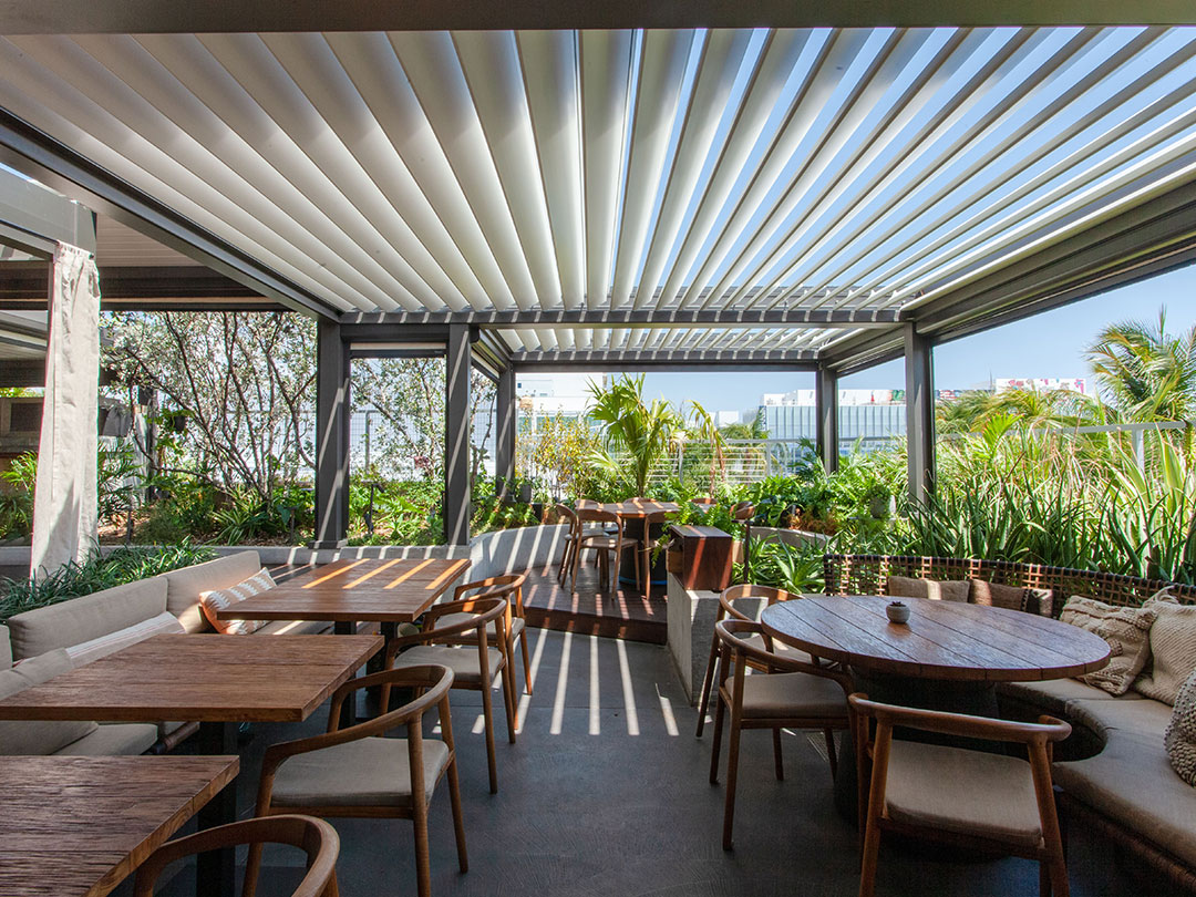 Terrasse de restaurant ombragée par une pergola bioclimatique