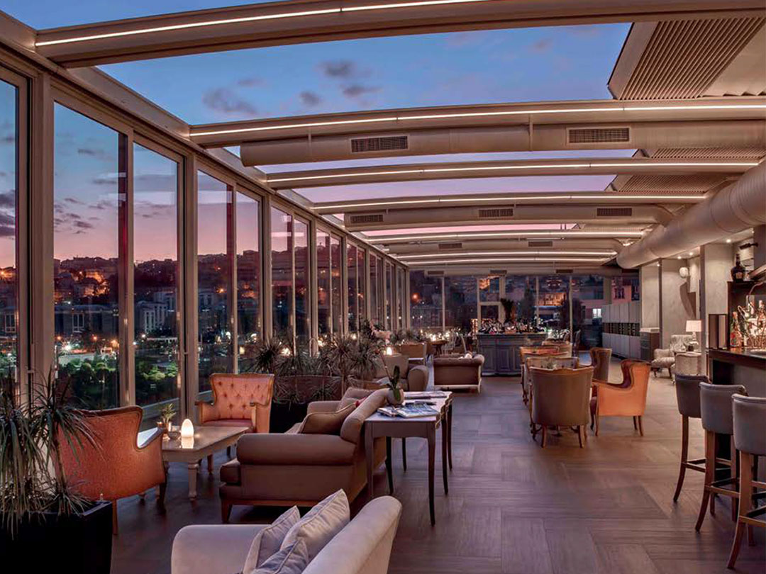 Aménagement intérieur d'un restaurant avec pergola bioclimatique et baies vitrées