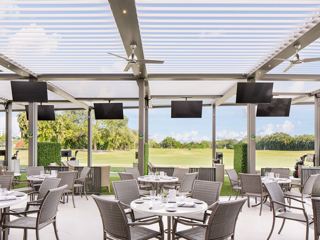 Terrasse ombragée avec pergola bioclimatique dans un club de golf