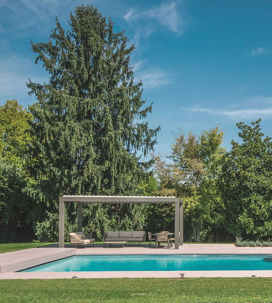 Pergola motorisée bioclimatique dans un jardin au bord d'une piscine